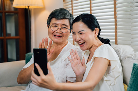 Asian mother and daughter making video call