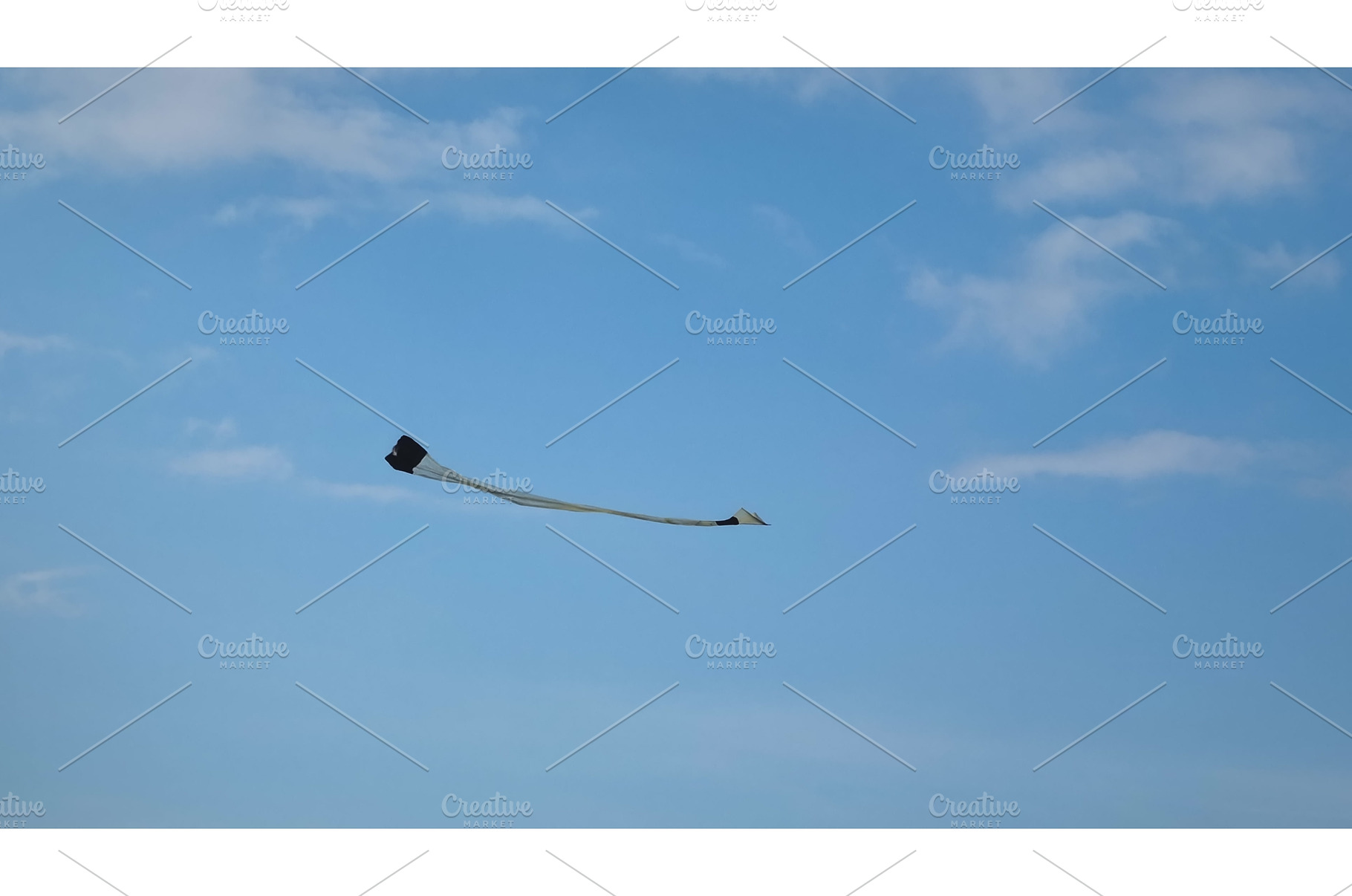 Kite flying in blue sky with clouds, a Nature Photo by Goinyk