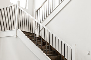 Modern white wooden staircase in new house interior with big windows, a Person Photo by travnikovstudio