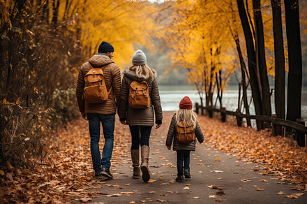 A family walking down a leaf covered path in autumn created with Generative AI, a Person Photo by OSORIOartist