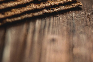 Stacked whole grain crispbread crackers on dark wooden table, showcasing health, a Photo by Studio ANNA