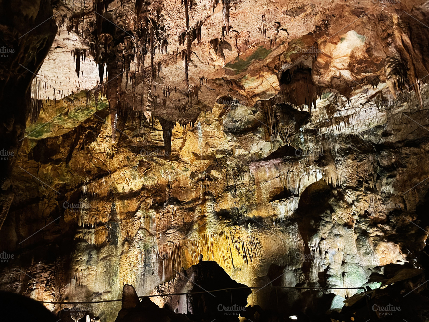 Illuminated stalactites and stalagmites within in Mira de Aire, Portugal., a Photo by AS photostudio