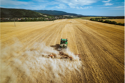 Aerial view of a harvester working, an Industrial Photo by HalfPoint