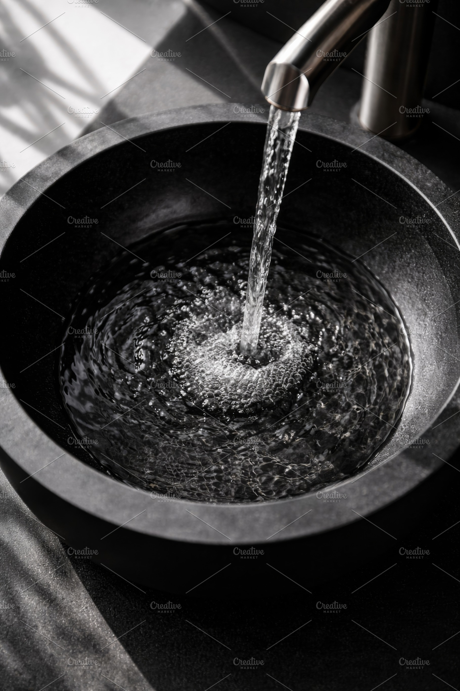 Water flowing into black stone sink, a Photo by Dvoevnore photos