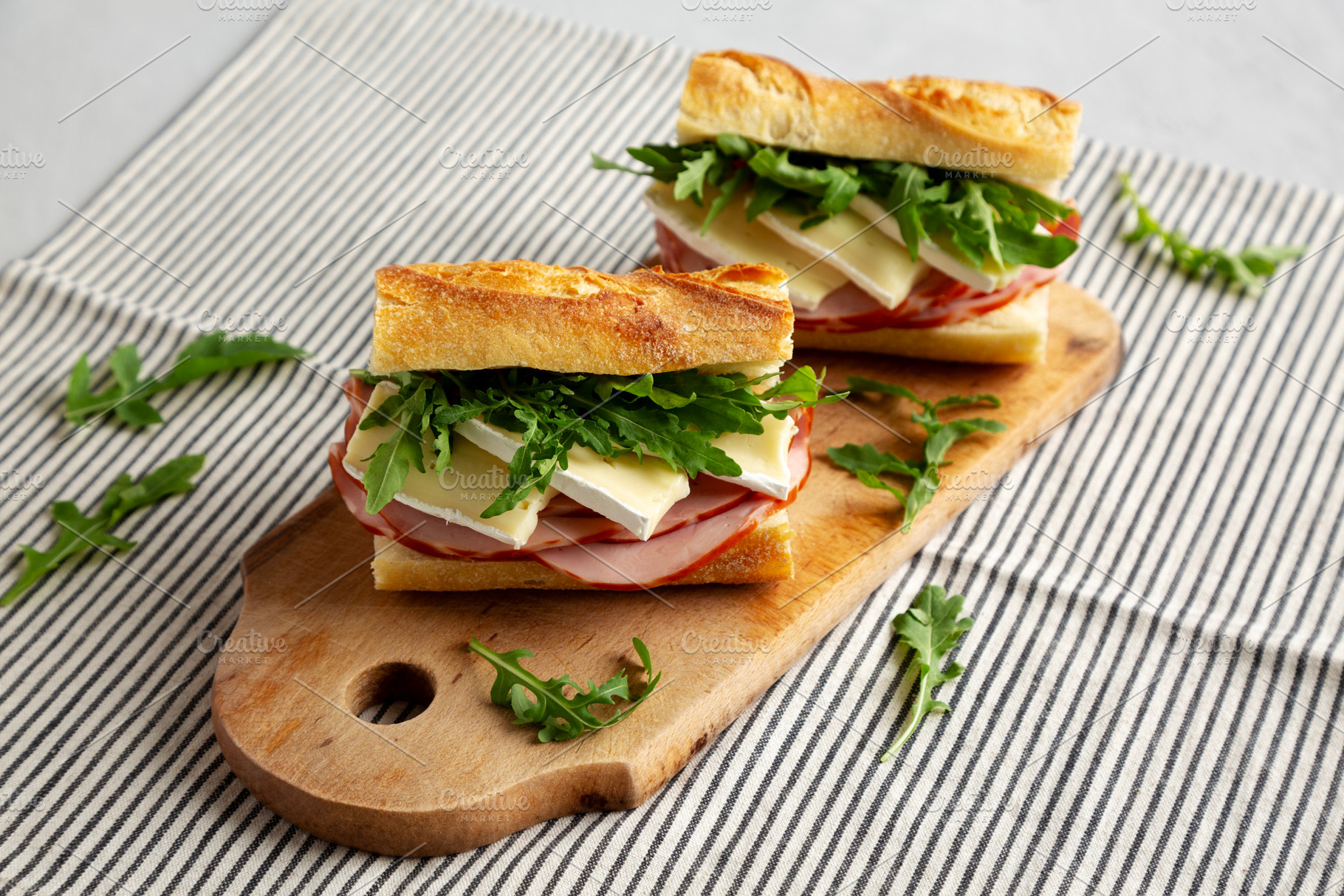 Homemade French Ham and Brie Baguette with Arugula Greens, side, a Food & Drink Photo by LiudmylaChuhunova