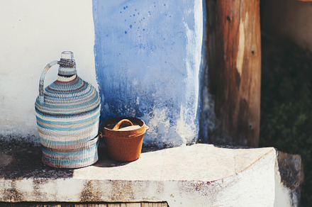 Rustic pot and bottle, stucco ledge