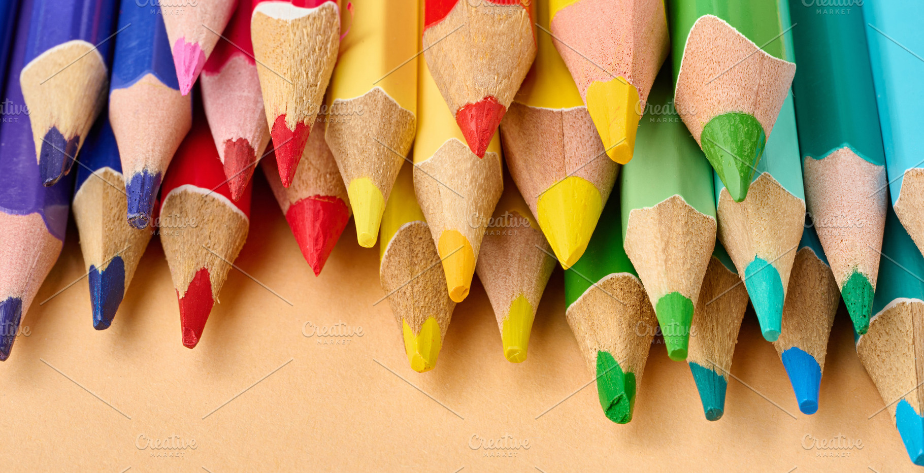 Multicolored wooden pencils stacked on a beige background, a Food & Drink Photo by ndanko