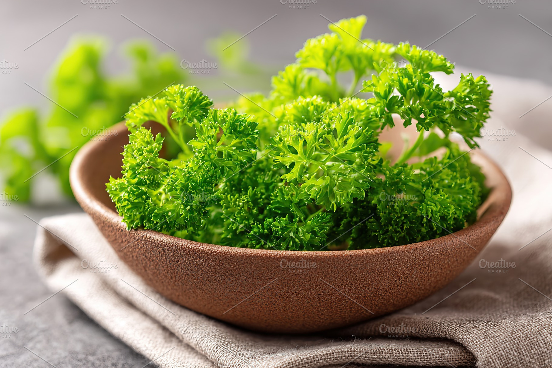 Fresh parsley bunches arranged in a rustic clay bowl on a textile surface, a Food & Drink Photo by AlyaAnd