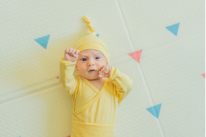 Adorable baby in a yellow hat lying, a Person Photo by Elizaveta Galitskaya