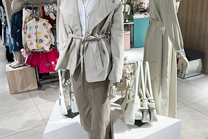 Fashion mannequins showcasing beige clothing styles in a retail display setting, a Photo by AS photostudio