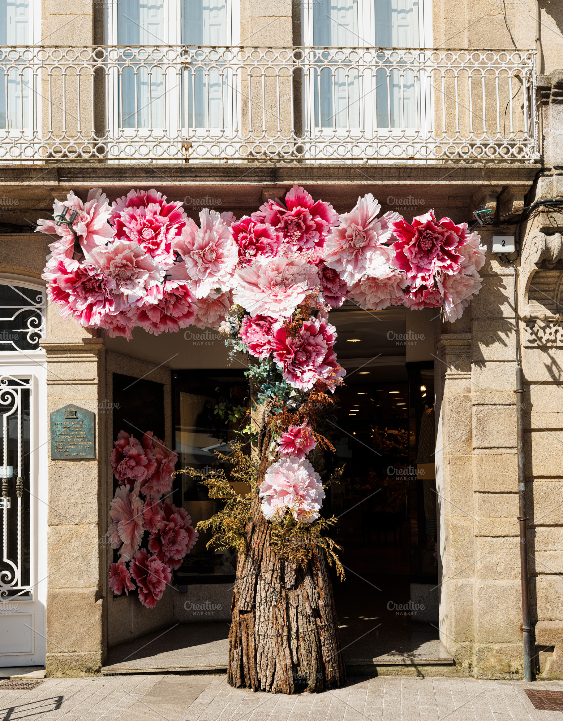 Decorative Pink Flowers Adorning a Building Entrance, Lugo, Spai, an Abstract Photo by Bepslabor