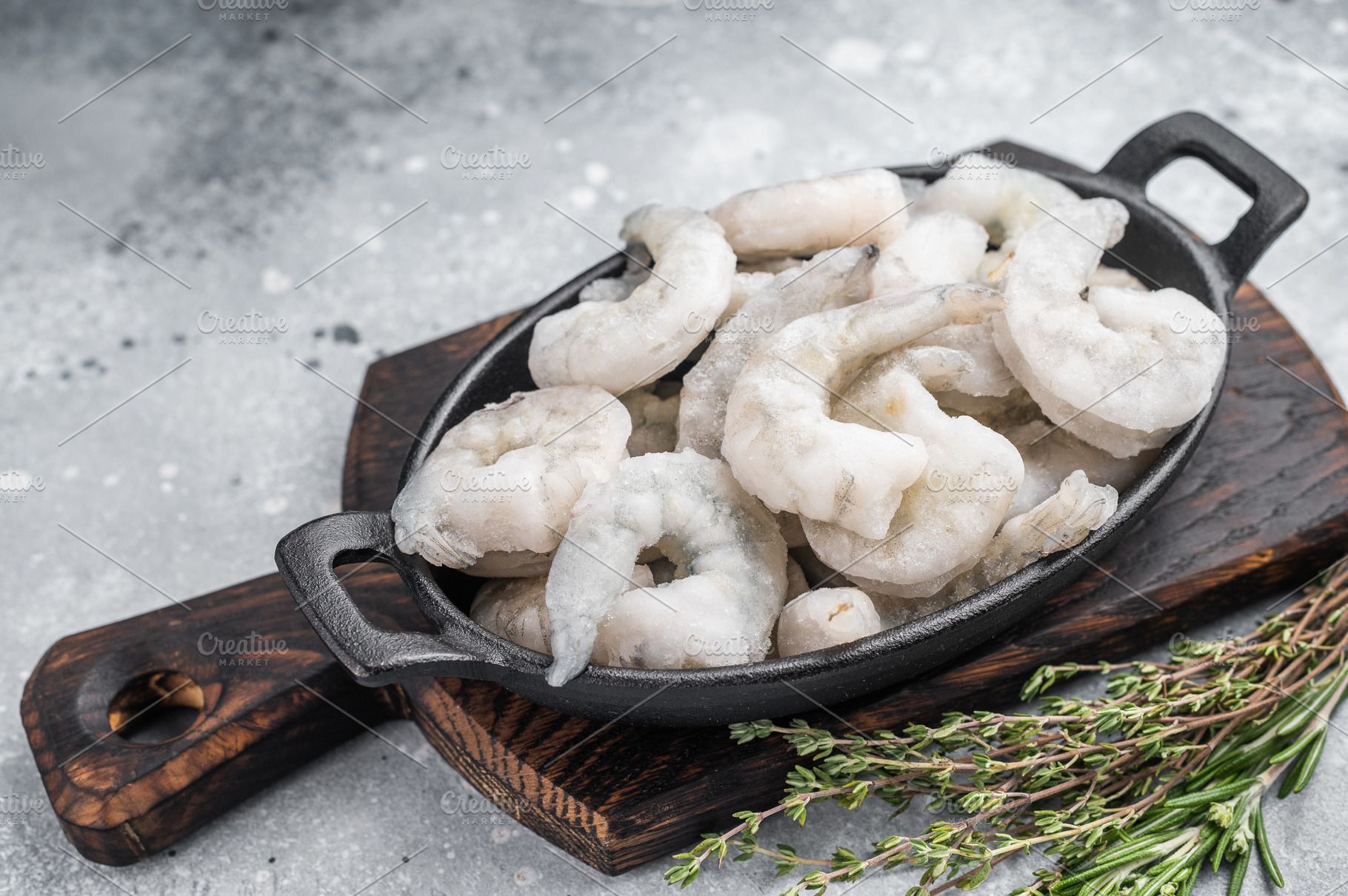 Frozen raw shrimp prawns in a rustic skillet with fresh thyme on, a Food & Drink Photo by composter-box@mail.ru