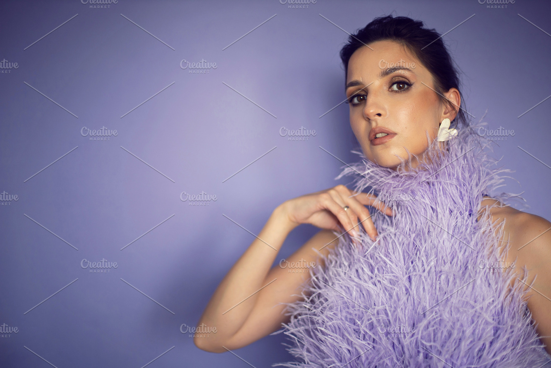 portrait woman in an evening purple dress with feathers stands in the backgroun, a Person Photo by SaulichPhoto