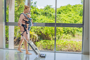 Woman vacuuming a room while, a Technology Photo by Elizaveta Galitskaya