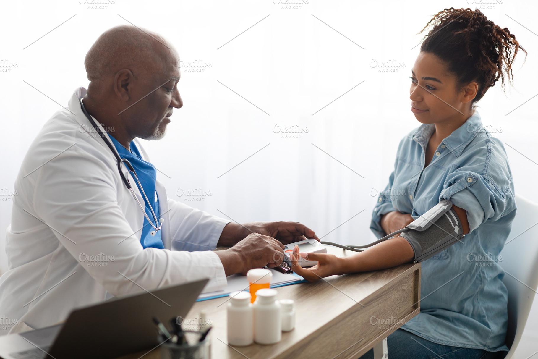 Black doctor checking measuring pressure on pregnant patient's hand pulse, a Photo by Prostock-Studio