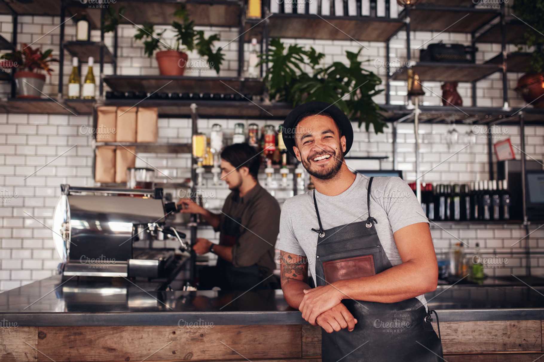 Coffee shop worker smiling featuring adult, apron, and background, a Person Photo by Jacob Lund