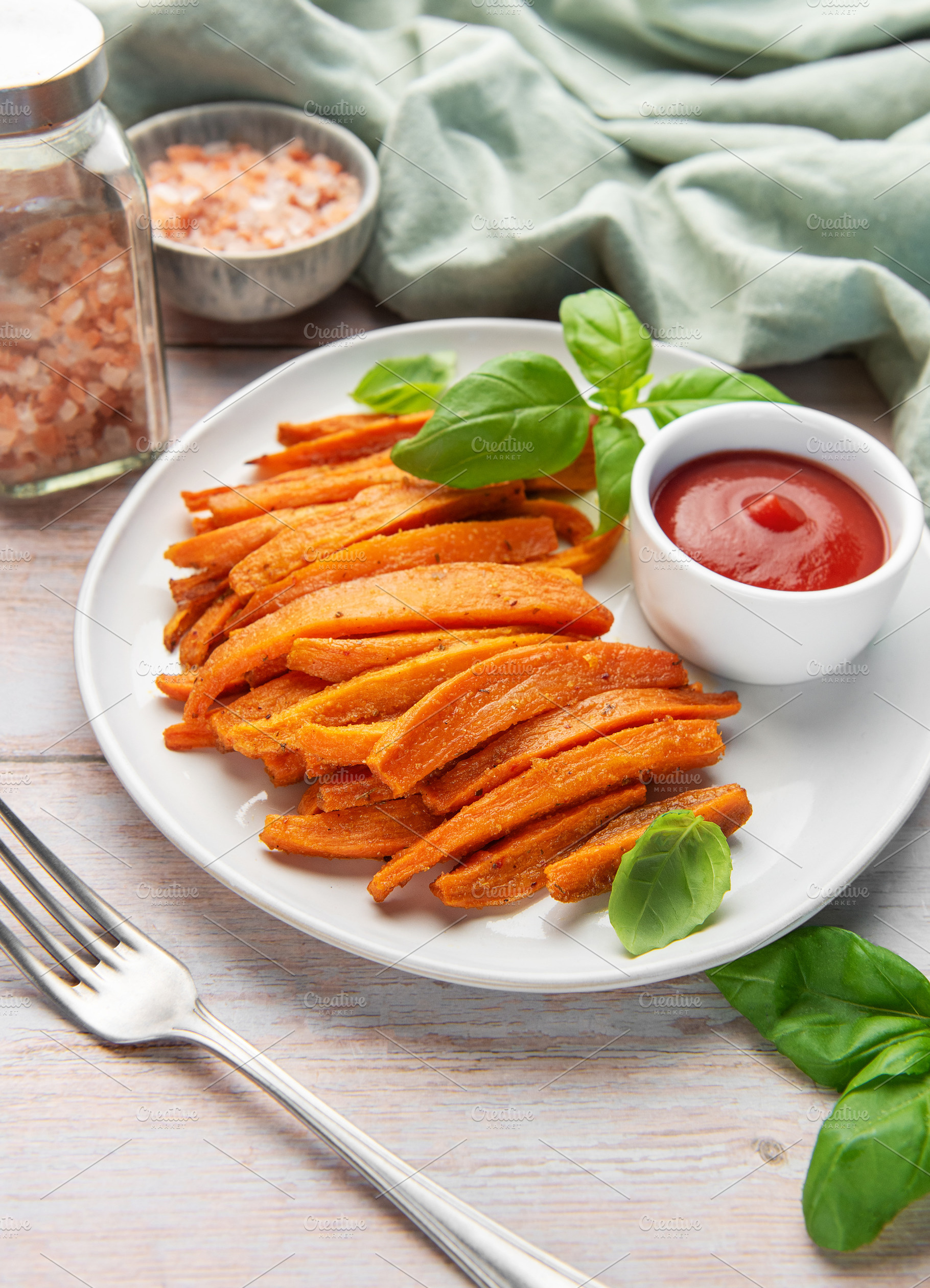 Sweet potato fries with ketchup and fresh basil leaves, a Food & Drink Photo by Olena Rudo