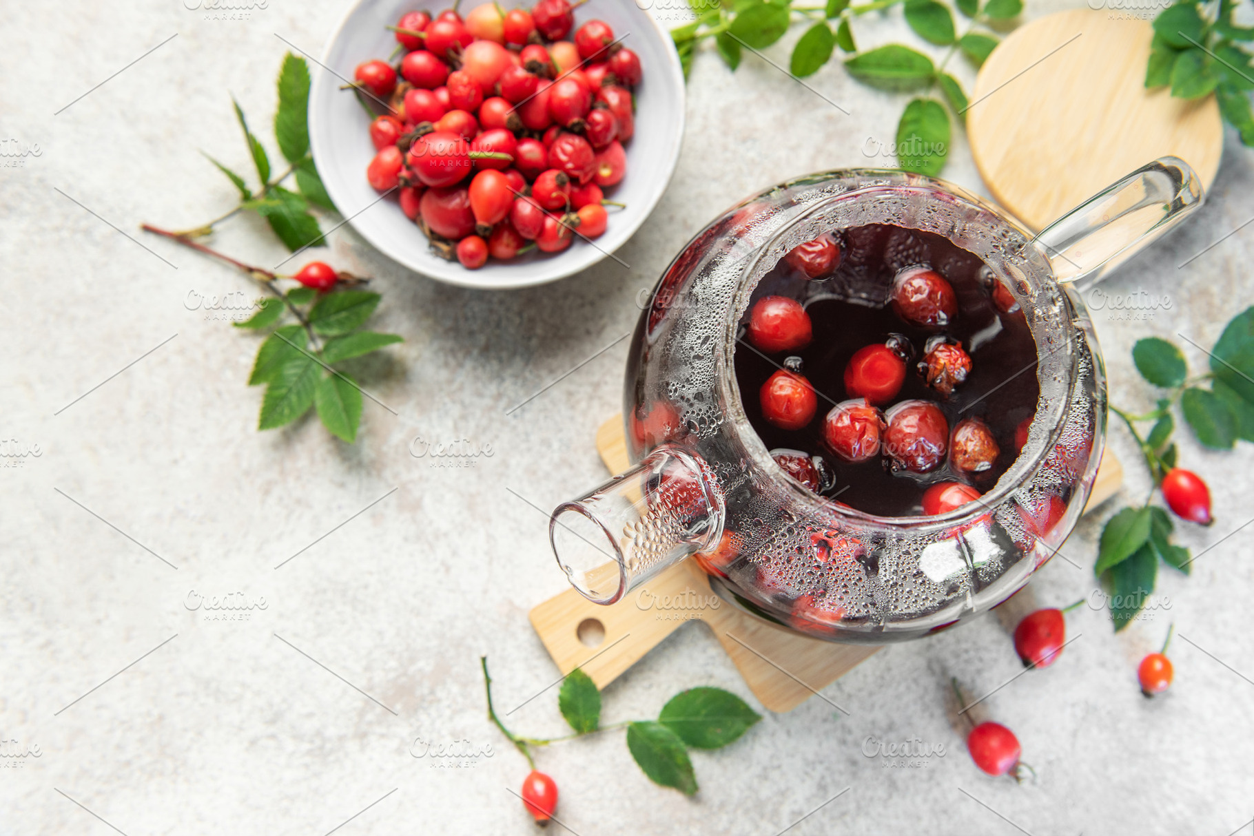 Steaming rosehip tea brewing in glass teapot with fresh rose hip, a Food & Drink Photo by Olena Rudo