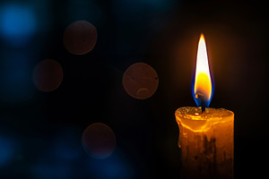 A lit candle stands prominent in the, a Photo by Iftikhar Alam
