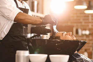 Single stylists hands applying hair color to a client’s hair s, a Beauty & Fashion Photo by DanFLCreativo