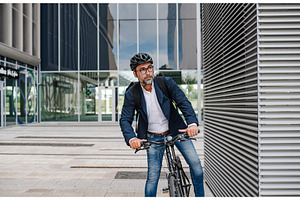 Man riding bike to work in city with, a Person Photo by HalfPoint