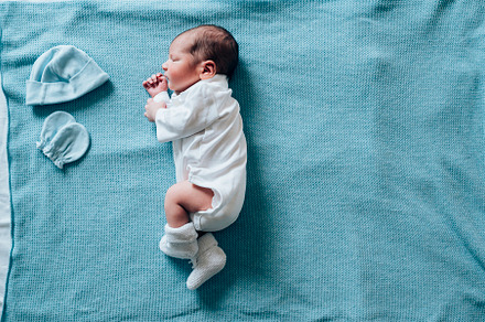 Newborn child sleeping on a blue bla stock photo containing boy and baby, a Person Photo by karrastock