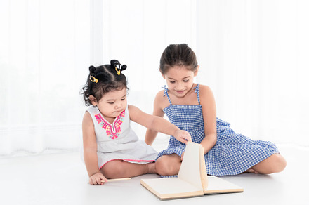 Happy two sister drawing in sketch book together at home or nurs, a Person Photo by Ministocker