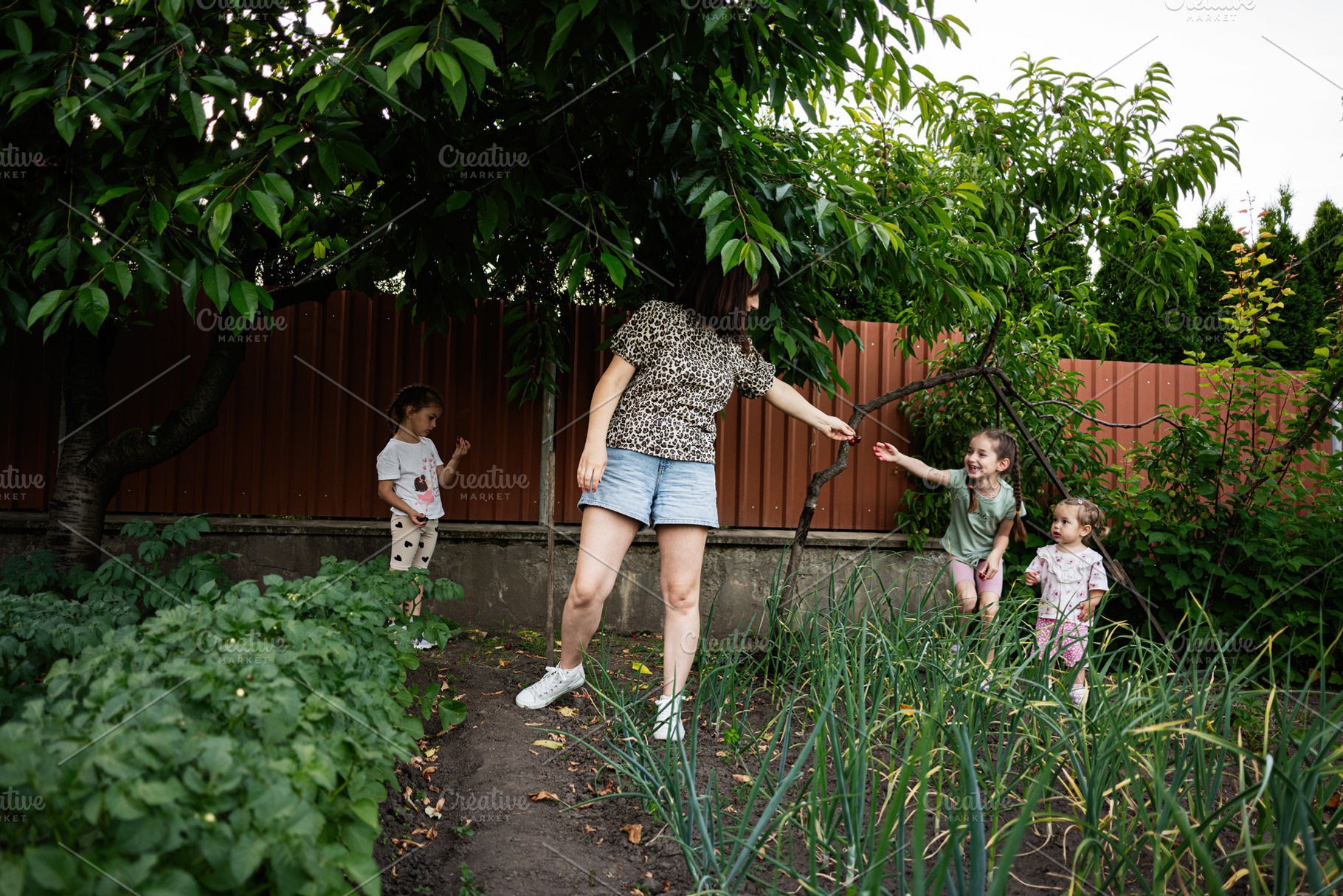 A family enjoying outdoor activities together in a lush garden setting, a Person Photo by AS photostudio