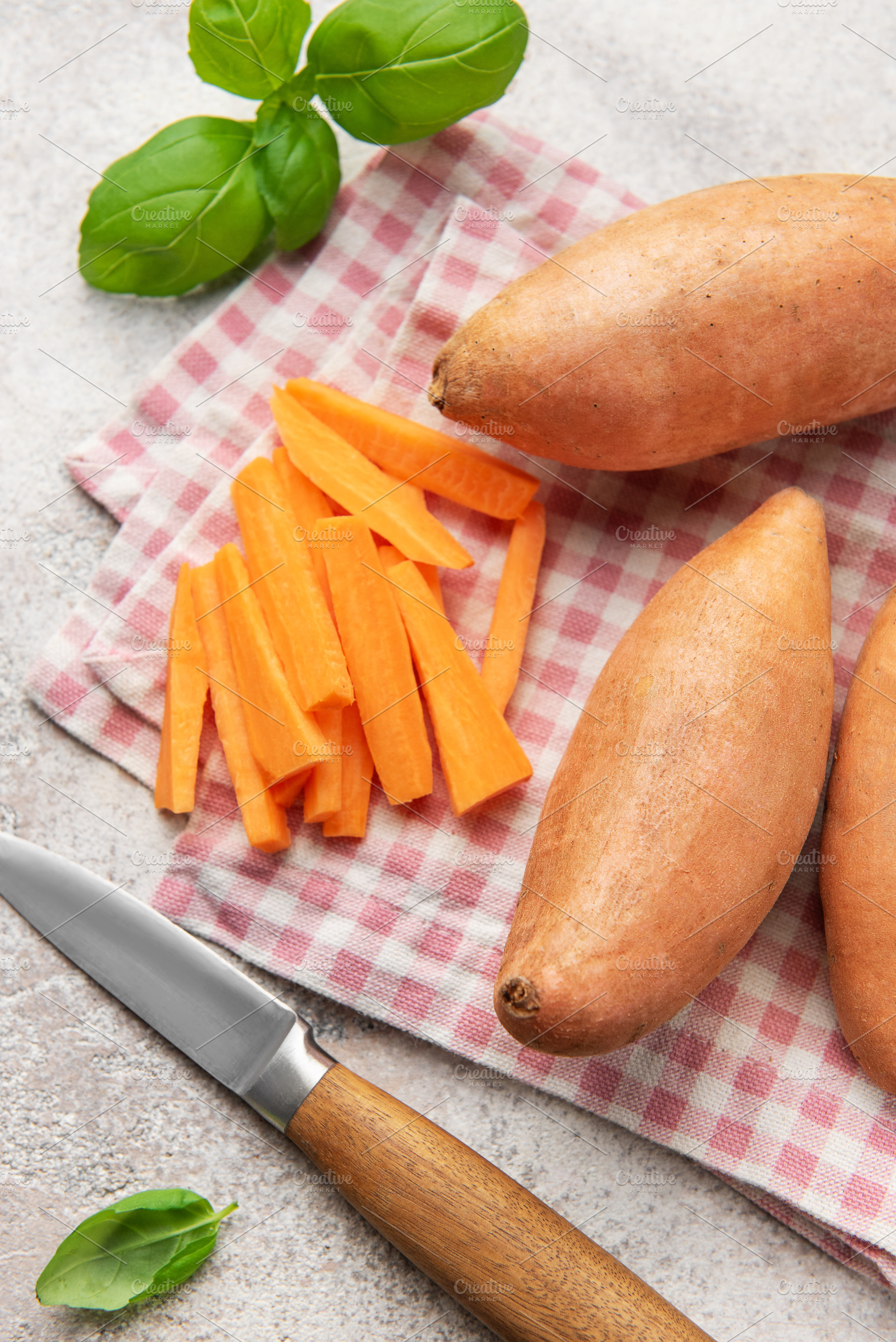 Preparing sweet potato fries with knife and basil on napkin, a Food & Drink Photo by Olena Rudo