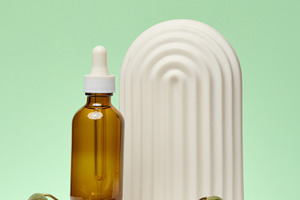 A bottle with a pipette, a jade facial massage roller and a deco, a Beauty & Fashion Photo by ndanko