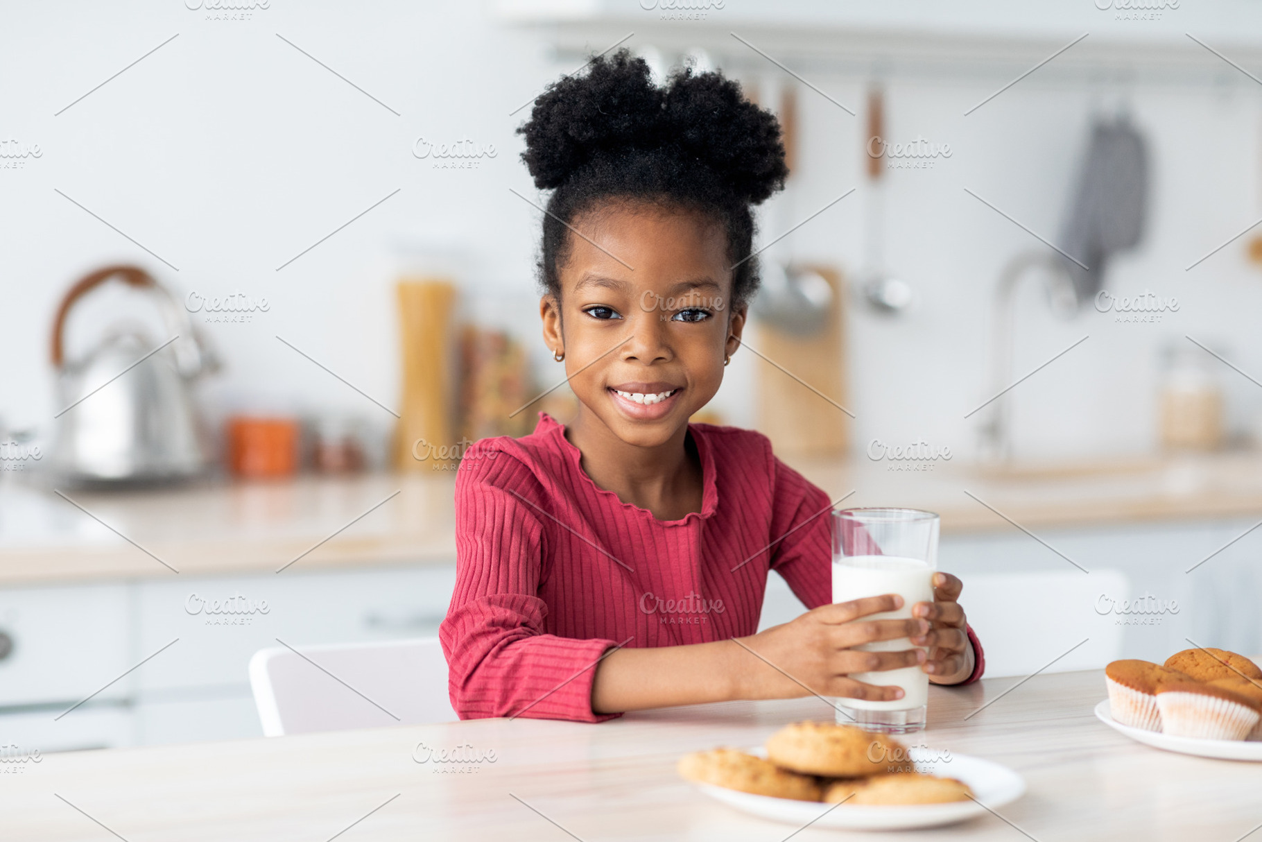 Cute african american little girl drinking milk, a Photo by Prostock-Studio