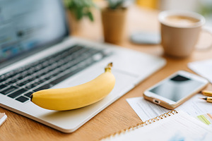 Business presentation setup with laptop, fruit, and office essentials on worksp, a Photo by AlyaAnd