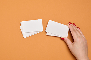 A woman's hand holds a stack of blank white business cards again, a Business Photo by ndanko