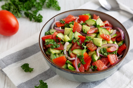 Homemade Mediterranean Cucumber Tomato Salad in a Bowl, side vie, a Food & Drink Photo by LiudmylaChuhunova