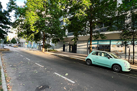 Urban street with small green car under sunny skies, a Photo by AS photostudio