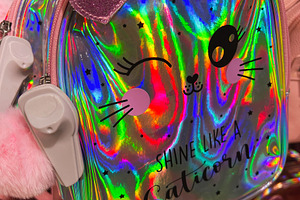 Holographic bag with cute pink ears and text design in vibrant hues, a Photo by AS photostudio