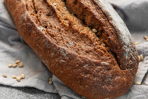 Fresh baked rustic dark bread loaf on towel, a Food & Drink Photo by Olena Rudo