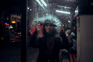 girl behind rain glass on night city