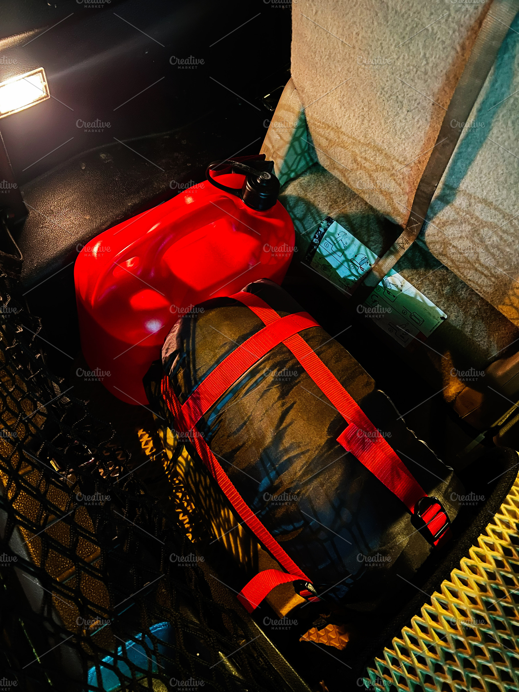 Compact travel cargo in a vehicle trunk with red gas can and strapped gear, a Photo by AS photostudio