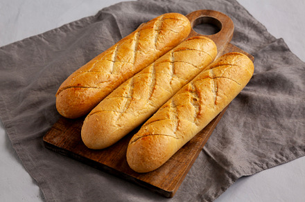 Homemade French Baguette with Garlic Filling on a wooden board,, a Food & Drink Photo by LiudmylaChuhunova