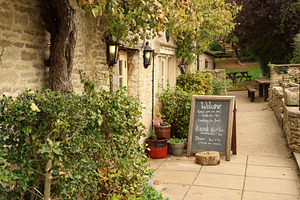 English country pub with stone facade and a welcome chalkboard m, a Photo by Studio ANNA