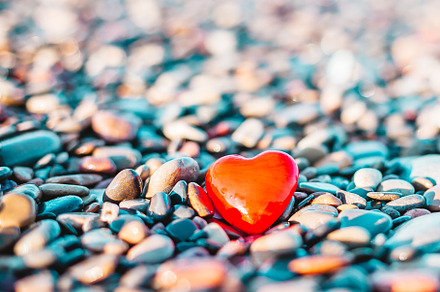 Romantic symbol of red heart on the pebble beach, a Photo by Dvoevnore photos
