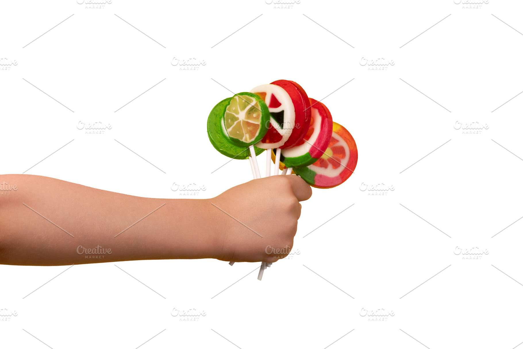 Child’s hand holding colorful fruit lollipops, isolated on whi, a Food & Drink Photo by Ales Munt