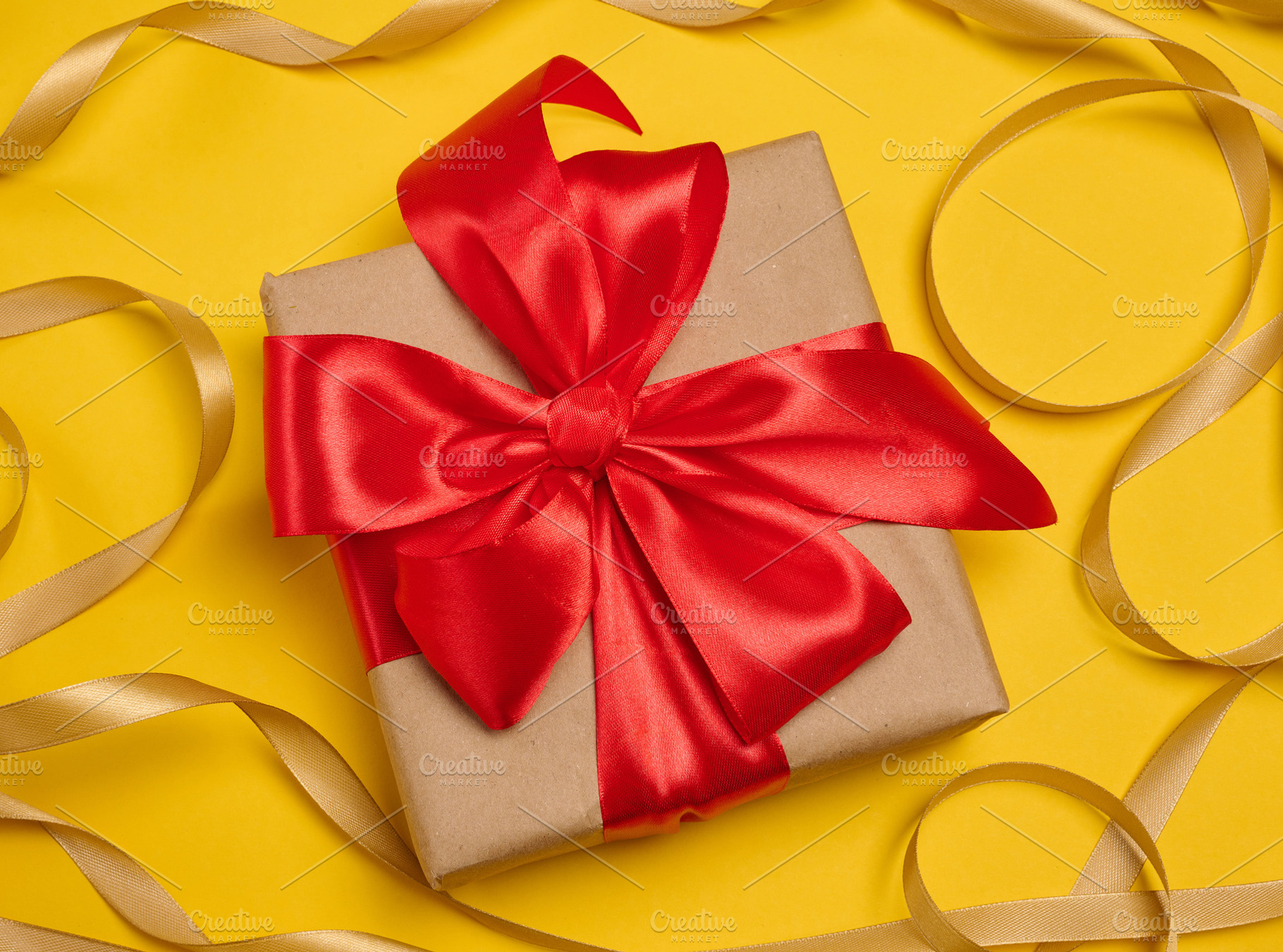 A gift box wrapped in craft paper and tied with a large bright r, a Holiday Photo by ndanko
