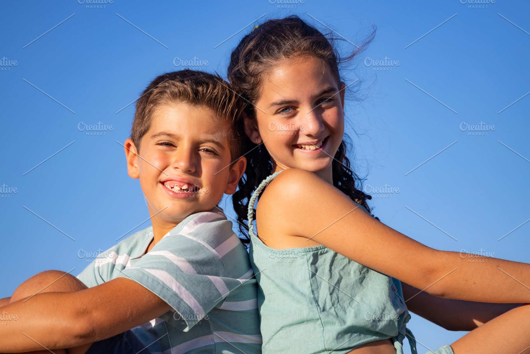 Two relaxed kids against blue sky at summer, a Person Photo by Cosca