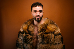 Confident man wearing stylish fur coat looking at camera, a Photo by karrastock