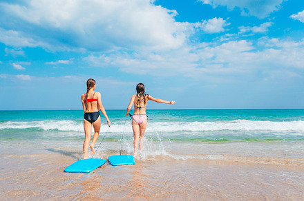 Adorable little girls have fun on the beach swimming and splashing, a Person Photo by travnikovstudio