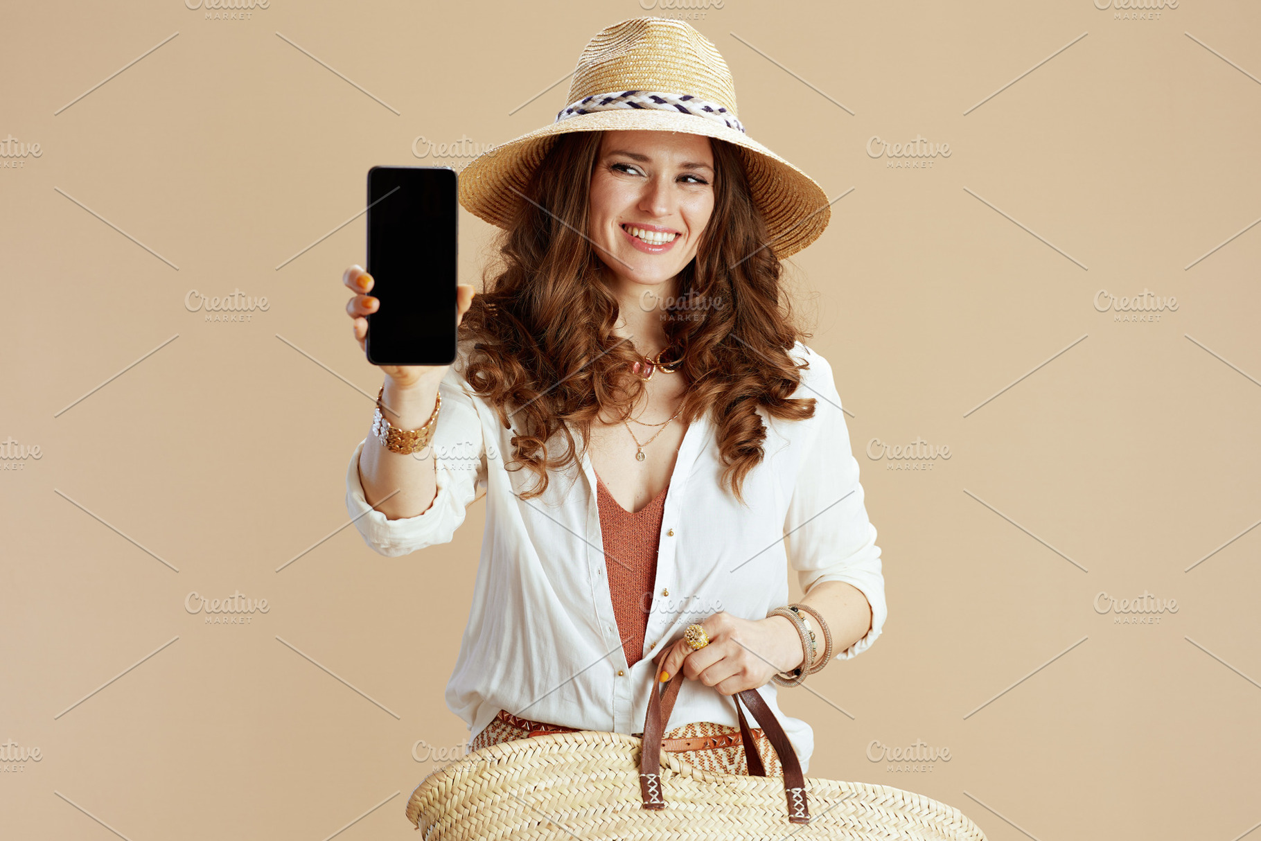 happy woman showing smartphone blank screen on beige, a Person Photo by Alliance Images