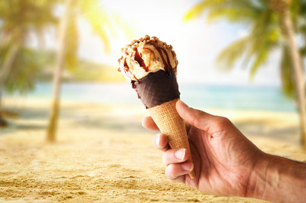 Hand holding ice cream cone on vacation with beach background, a Food & Drink Photo by Davizro's Market