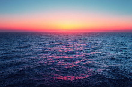 Vibrant sunset over calm ocean water, a Photo by Tanuart